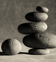 A small stone beside a larger stack of dark stones